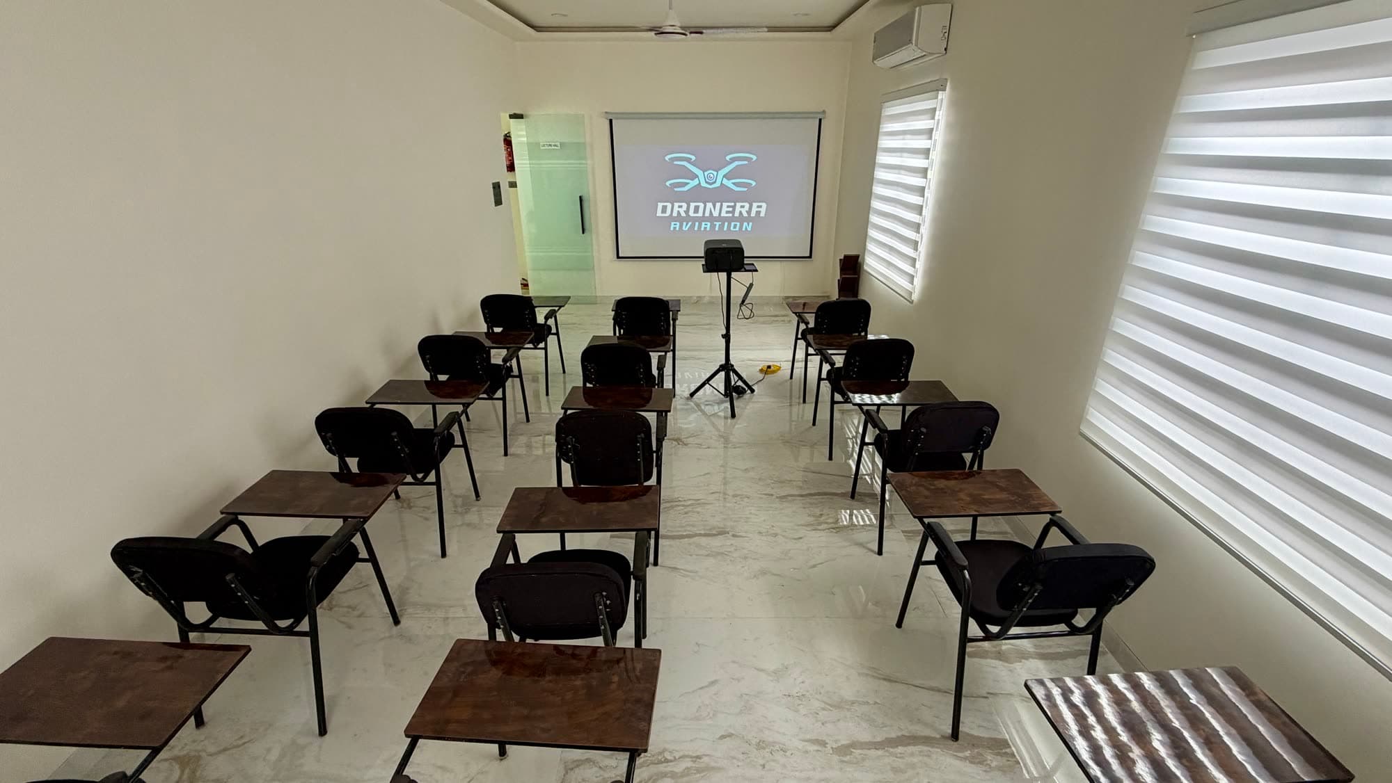 Dronera classroom with projector and student desks